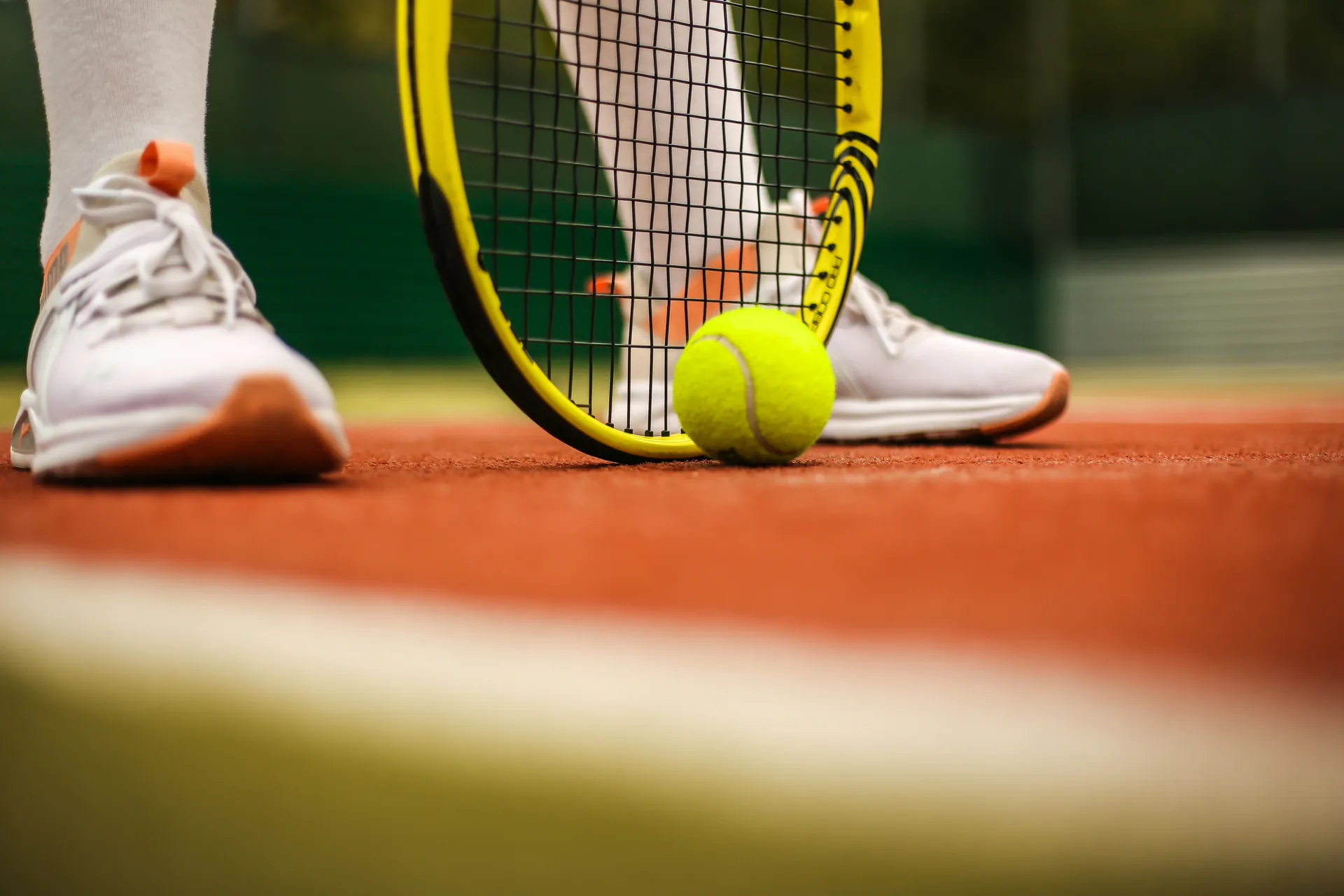 Cancha de tenis con zapatillas, raqueta y pelota